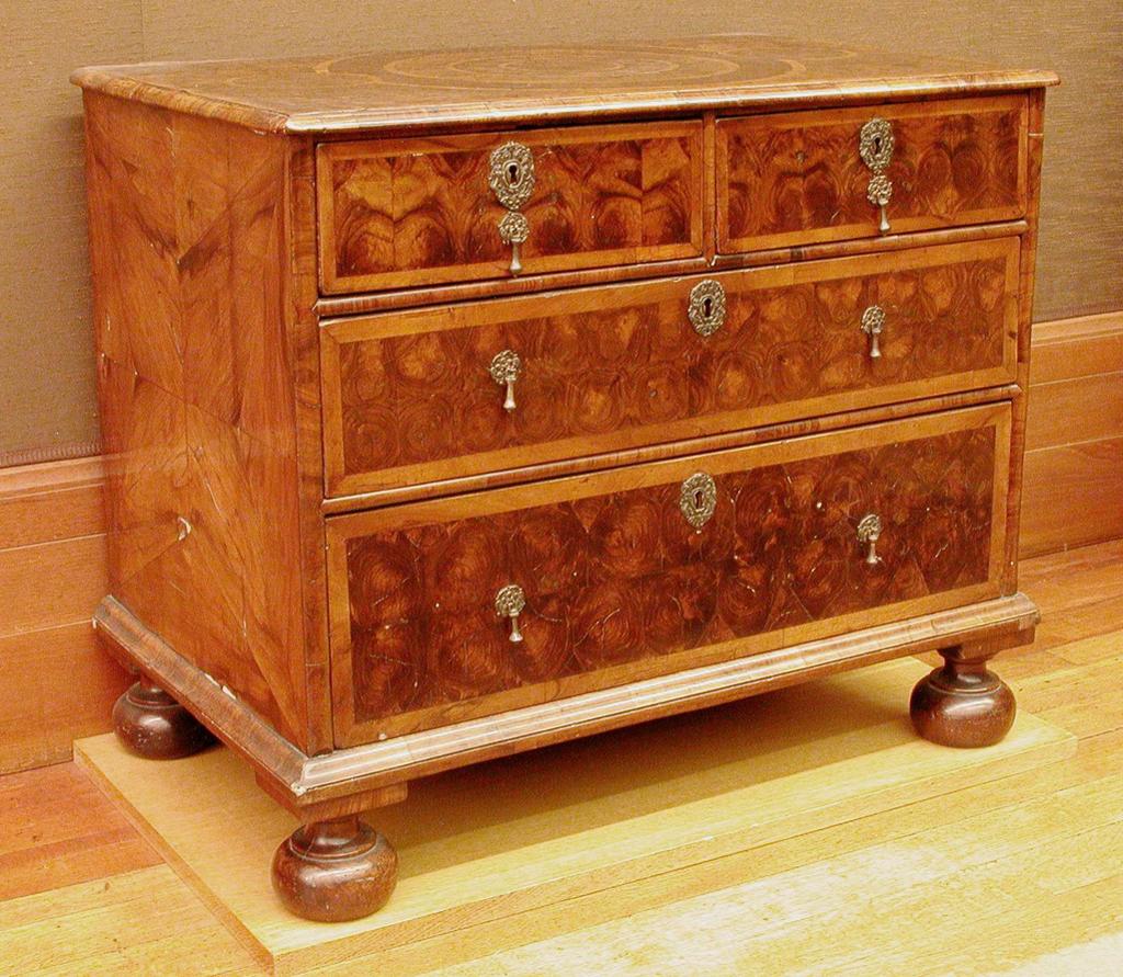 An image of Furniture. Chest of drawers veneered in walnut with two short and two long drawers with drop brass handles. Unknown production, England. Walnut, veneer, brass (alloy) handles, circa 1690-circa 1700. William and Mary.