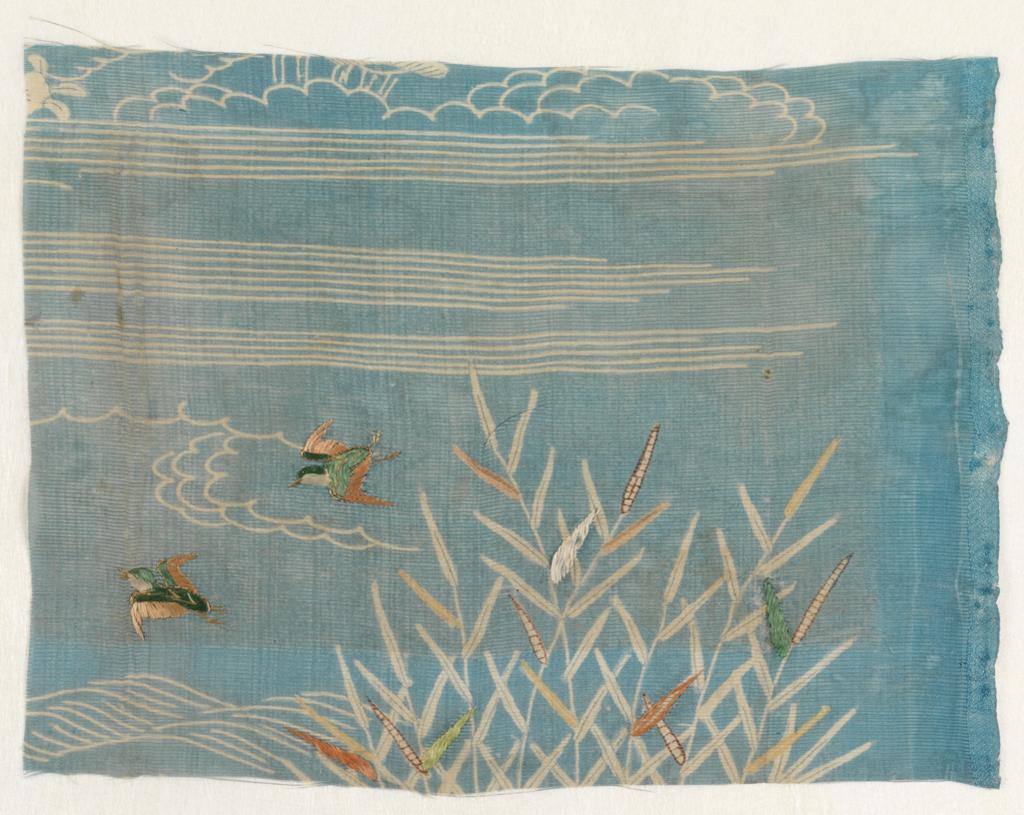 An image of Textiles. Sample. Unknown maker, Japan. River scene with bullrushes and ducks. Silk gauze, resist-dyed blue; painted and stencilled details in browns and yellows. Silk and metallic embroidery; satin, stem stitch and couching in green, orange, yellow and gold. Length, whole, 32 cm, width, whole, 24 cm, circa 1700. Acquisition Credit: Given by Mrs. Soame Jenyns, in accordance with the wishes of her late husband, Soame Jenyns.