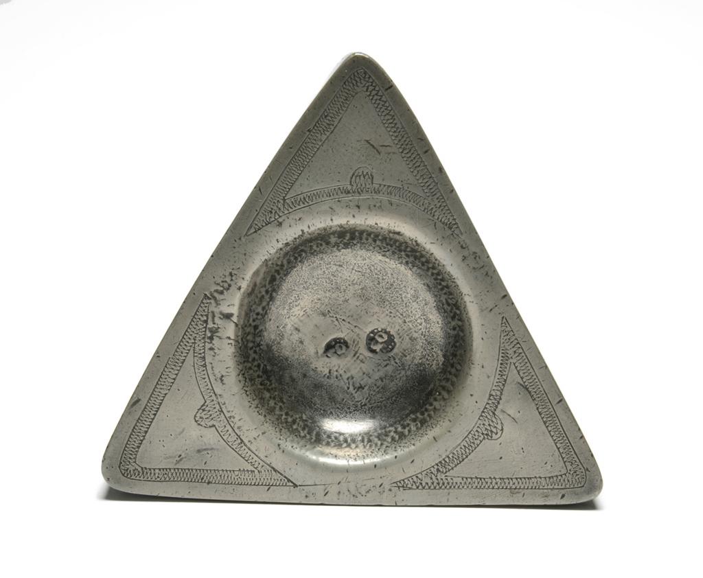 An image of Salt. Unknown production, England. Triangular pewter salt, with wrigglework. Incised with the initials 'EHC'.  Marked SO in a dotted circle, and struck twice. Pewter, incised, engraved, height, 2.5, cm, circa 1650. Declared fake by the Pewter Society, October 1953. Style of mid 17th century. Collection: Antonio de Navarro Collection.