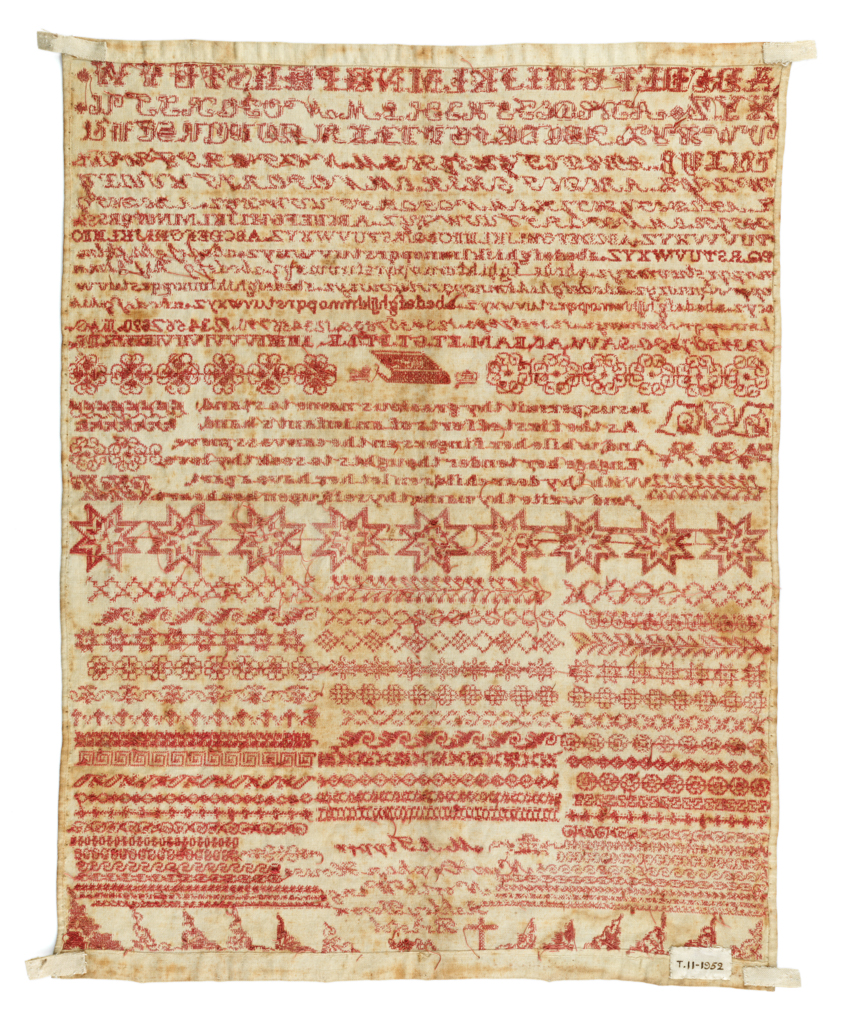 An image of Embroidery sampler/Marking sampler. Tipper, M. A., Bristol.  The pattern includes a row of alphabets, numerals, abstract and geometric flowers and a verse which reads 'Jesus, permit thy gracious name to stand/ As the first efforts of an infant's hand, / And, while her fingers on the canvas move/Engage her tender thoughts to seek thy love, / With thy dear children let her have a part, / And write thy name thyself, upon her heart'. In the flower band above the verse a bible motif is inserted and we equally find a row of paired initials, whilst below it short bands of repeat motifs take up most the bottom half of the sampler which also contains the inscription 'M.A. Tipper/ orphan house/ North Wing/ Ashley Down/ Bristol/ 1868'. Embroidered with red cotton in cross and four-sided cross. All the edges are hemmed. Length 37.5 cm, width 29 cm, 1808. English.