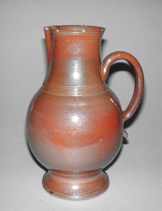 An image of Decanter Jug. Production Place: Nottingham. Brown salt-glazed stoneware, thrown and incised, dated 1702. Provenance: From Firtchley near Crich.
