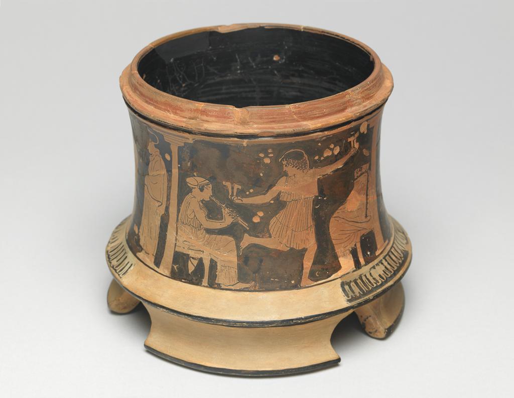 An image of Pyxis. Cosmetic vessel. Women indoors. Production Place: Athens. Clay, red-figured, diameter 0.11 m, height 0.127 m, 460 B.C. Classical Period.