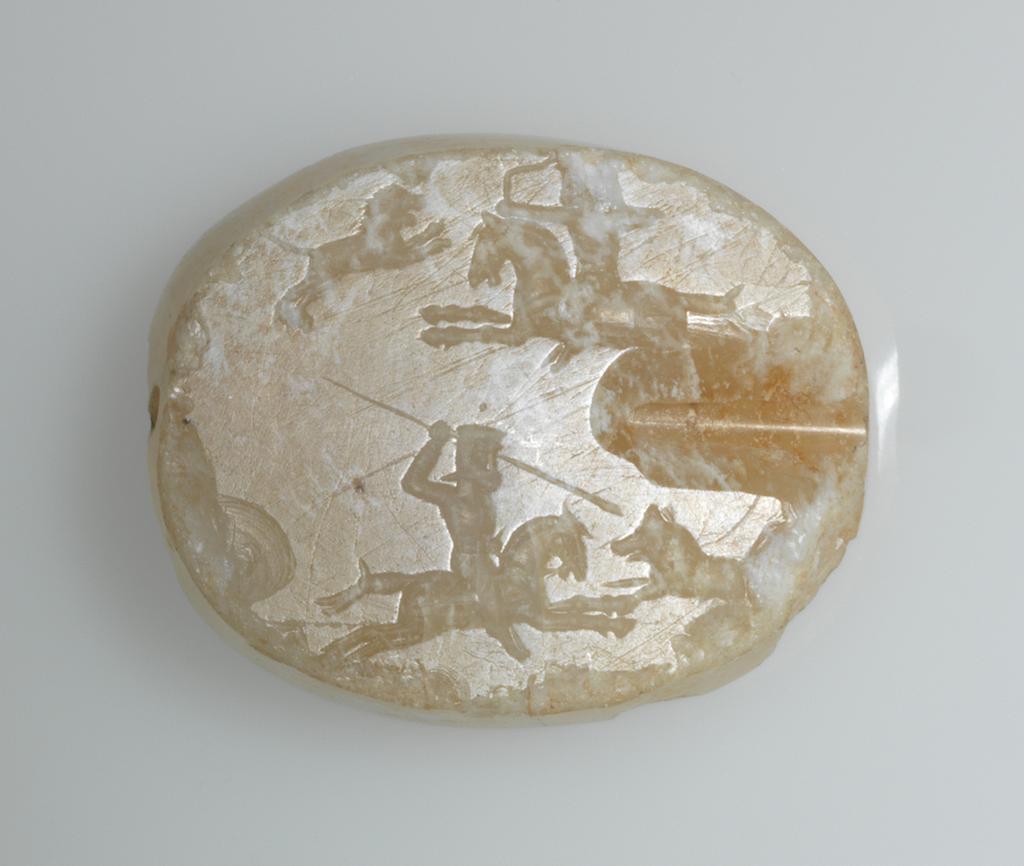 An image of Scaraboid Seal/Stamp Seal. Incised with hunting scene in which a horseman, facing right, discharges an arrow at a lion. Below, a second horseman, facing left, spears a wild boar. Chalcedony, cloudy, depth 0.025 m, length 0.012 m, width 0.031 m, 500-301 B.C. Graeco-Persian.