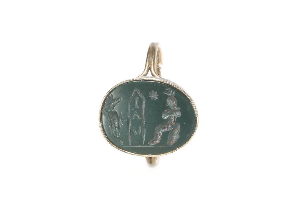 An image of Engraved gems. Magical amulet. Obverse: an ithyphallic and possibly mummified Anubis to the right confronting a figure seated upon a rock. The figure seems also to be bandaged like a mummy and, from the arms bent across the chest- the characteristic gesture of the god who holds the flail and sceptre- and a misconstrued atef crown, this seated mummy can be identified as Osiris. Between the two- Osiris and Anubis- are a star and an obelisk which bears the vertical inscription. Reverse: blank. Intaglio cutting, green jasper, 18 mm x 14 mm, circa 100-circa 300. Roman Imperial.