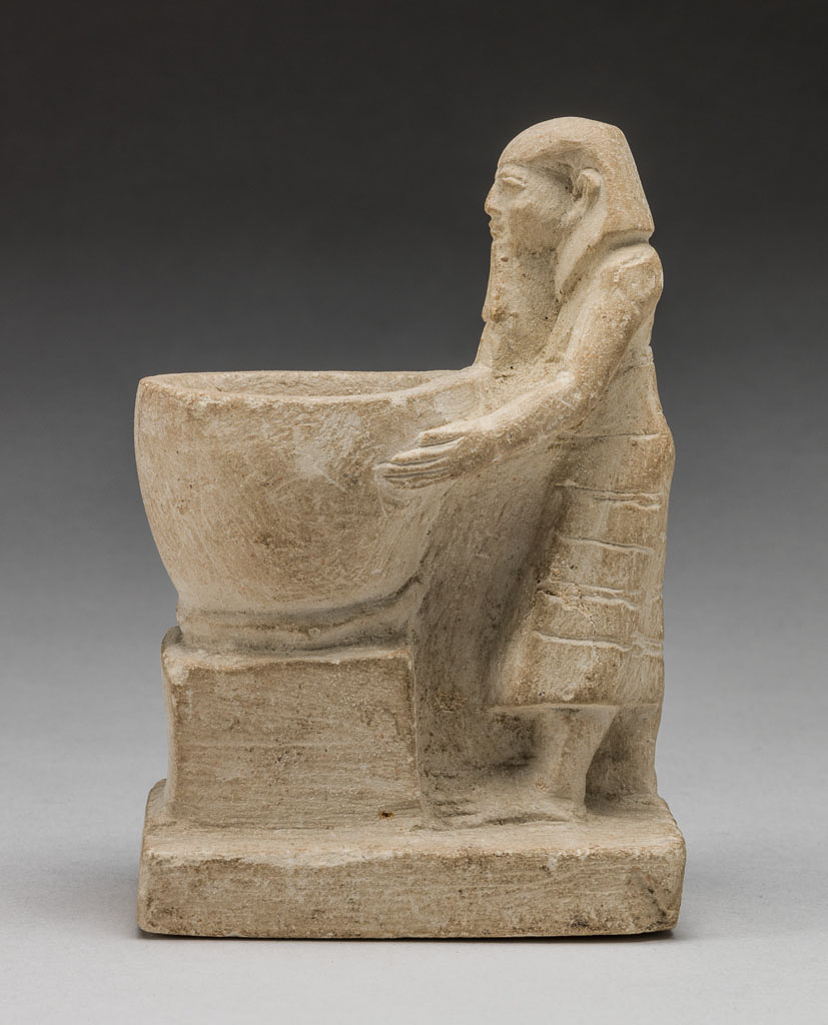 An image of Figure/Statuette. Priest, standing, holding a large bowl before him. Production Place: Egypt. Find Spot: Haragah, Egypt. Limestone, carved, length 8.6 cm, 2055 -1650 B.C. Twelfth Dynasty. Middle Kingdom.