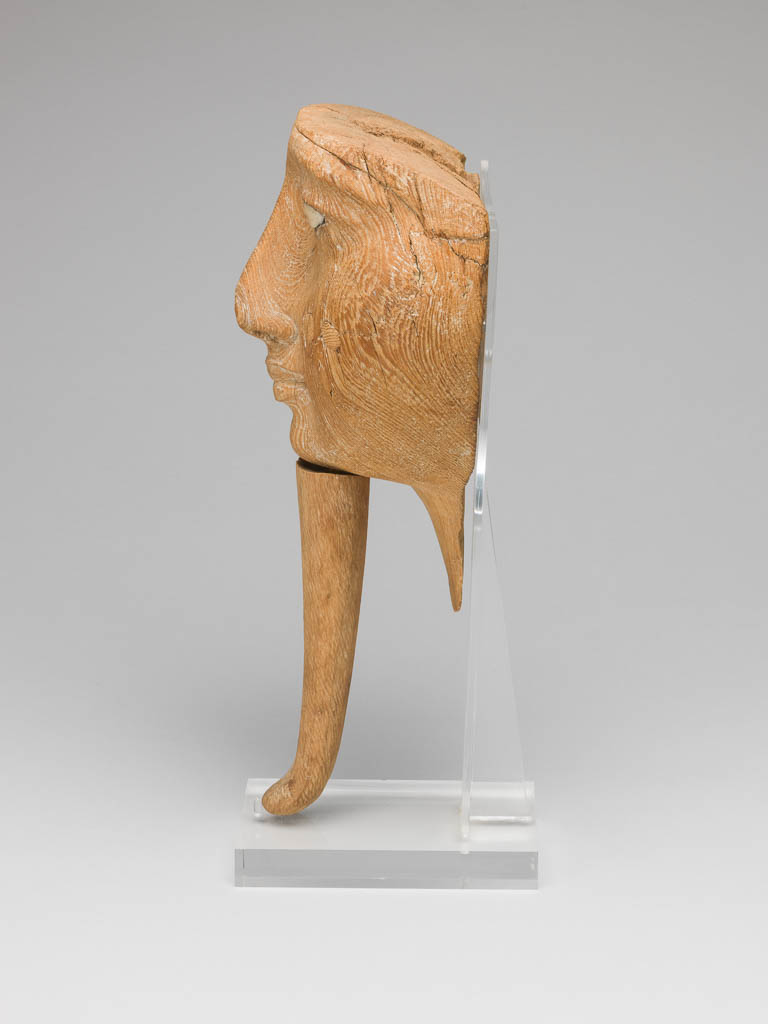 An image of Funerary equipment/coffin. Face from coffin, with inlaid eyes and attached beard. Production Place/Find Spot: Egypt. Wood, depth 9.5 cm, length 25.25 cm, width 13.9 cm, 1186-1069. Twentieth Dynasty. New Kingdom.
