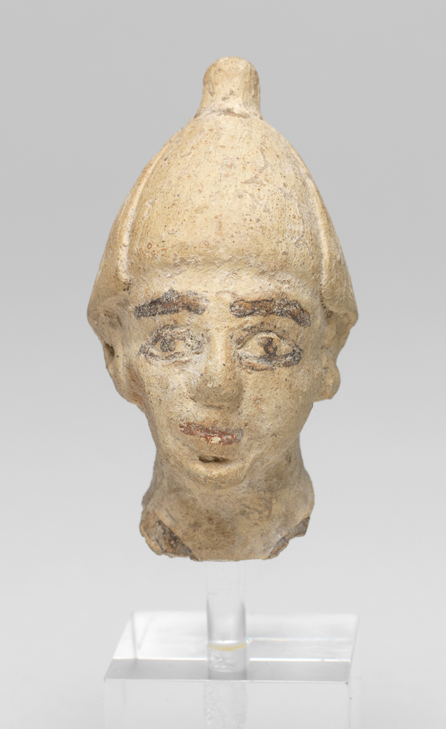 An image of Figure/Head. Male head, wearing cap. Production Place: Cyprus. Find Spot: Salamis, Cyprus. Clay, moulded, height 0.063 m, width 0.033 m, 600-501 B.C. Archaic Period.