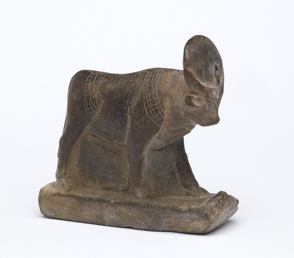 An image of Figure/Statuette. Apis bull, standing on sledge. Production Place/Find Spot: Egypt. Length 0.058 m, width 0.052 m.