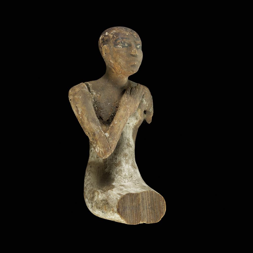 An image of Figure/statuette. man, seated, with right arm on his chest, left arm and legs are missing. Height 0.13 m. Middle Kingdom.