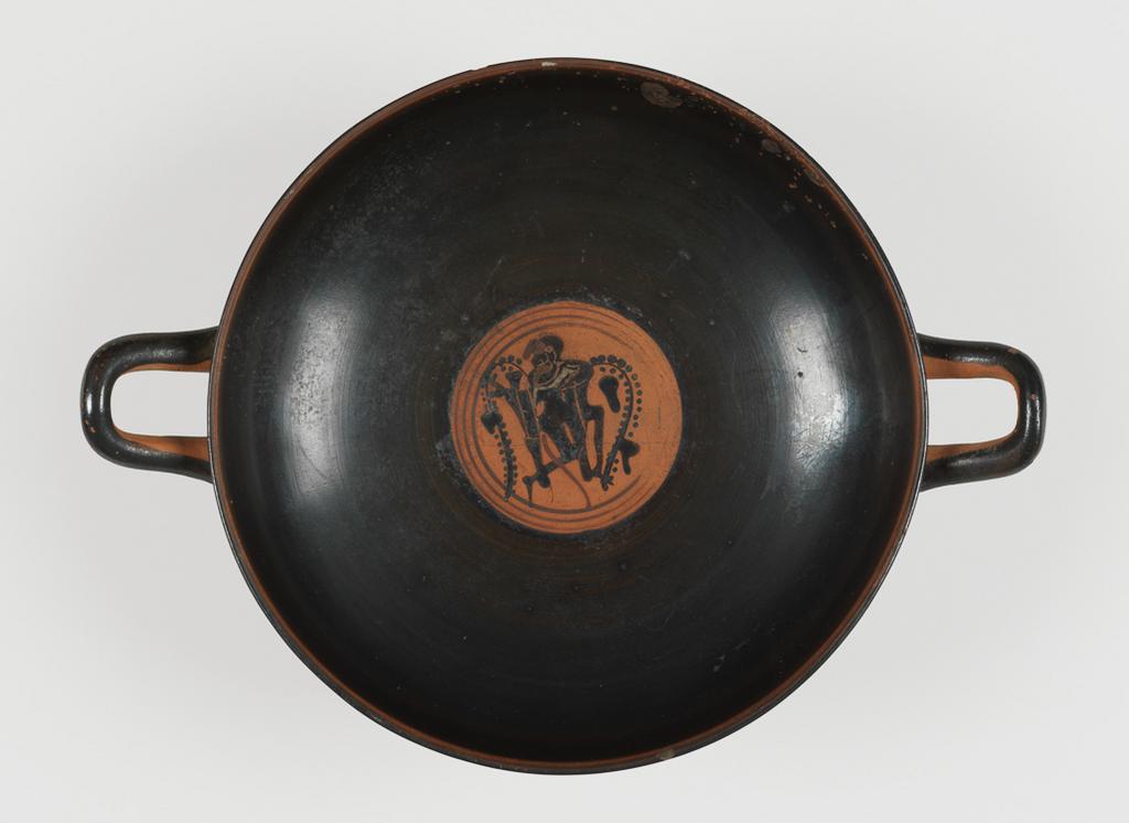 An image of Cup/Vessel. Dionysos, satyrs and donkeys, dolphin. Production Place: Athens. Clay, black-figured, height 0.083 m, width 0.273 m, diameter 0.202 m, diameter 0.068 m, 490 B.C. Archaic Period.