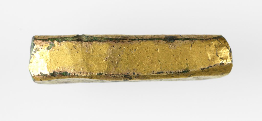 An image of Fragment. A curved section of gilt copper-alloy. It is square in cross-section and is broken at both ends. It has been worked as each of the four faces are flat and the vertices have been hammered into small flat surfaces as well. Find Spot: Torksey, Lincolnshire. 500-1500. Medieval.