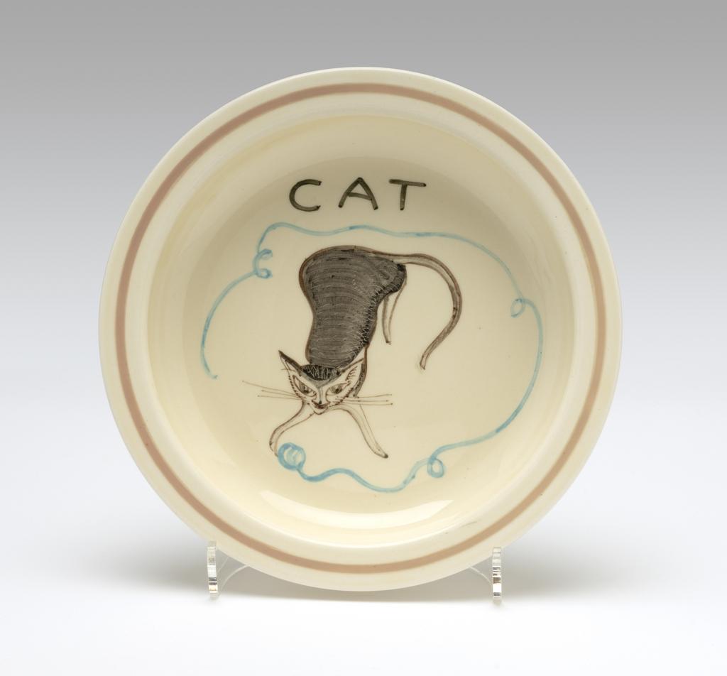 An image of Child's dish. Cooper, Susie (British, 1902-1995). Wood & Sons Ltd (Maker). Circular with deep sides and flat rim. Underglaze painting of a cat in brown-black, chasing a ball of blue wool which unravels around it. Band of pale brown around the rim. Underside concave withing foot-rim. Earthenware, moulded, painted underglaze. Diameter 17.3 cm, height 3.8 cm. Circa 1934-1938. Given by Timothy Barker, son of Susie Cooper and Cecil Barker.