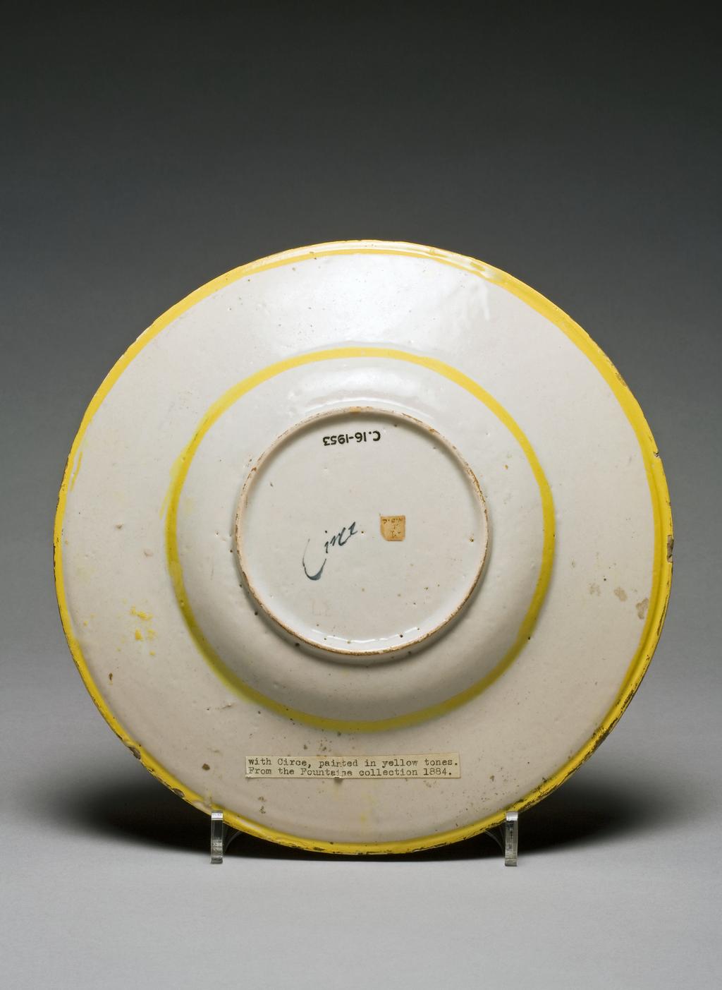 An image of Maiolica dish. 'Circe offers a Magic Potion to the Companions of Ulysses'. Zenobia Painter, workshop. Pale buff earthenware, painted in polychrome, tin-glazed overall; the reverse pale beige, height 4.0 cm, diameter 28.2 cm, circa 1550-1575. The Marches, Pesaro, Italy.