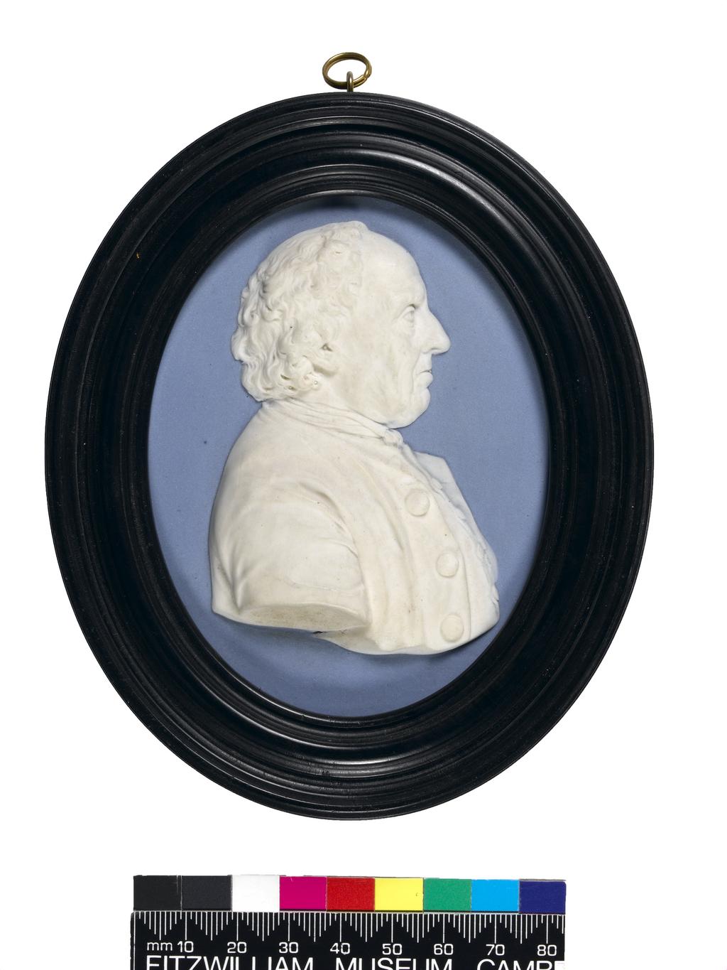 An image of Stoneware / Medallion. Portrait Medallion of Edward Bourne. Wedgwood Factory, Staffordshire. Hackwood, William, modeller, modeller (c. 1757-1839). Pale blue jasper plaque with applied moulded white jasper bust portrait in relief, and incised signature and inscription, height, frame, 13.5 cm, width, frame, 11.3 cm, 1779. Production Note: This is one of very few original medallions by the modeller William Hackwood. The sitter, Edward Bourne, a bricklayer at Wedgwood's factory at Etruria, was known as ‘Old Bourne’. Neoclassical.