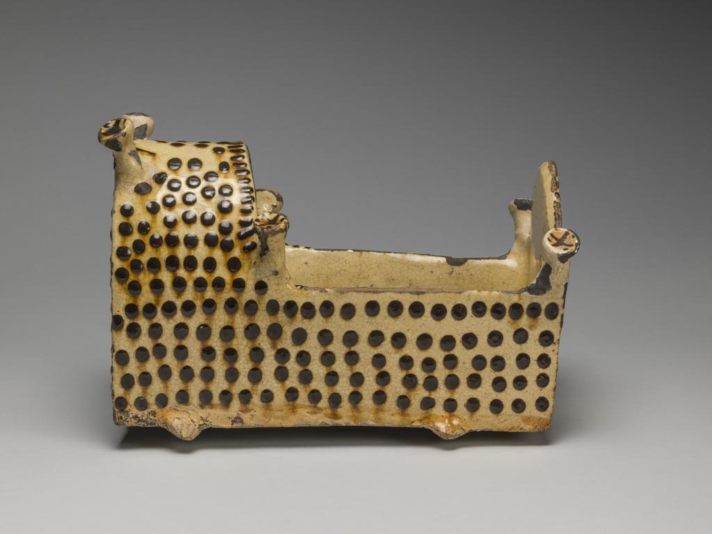 An image of Model Cradle/Commemorative Crib. Inscribed, 'MARY OVERTON – HER CRADEL, 1729'. Staffordshire pottery. Lead-glazed earthenware, slipware. English.