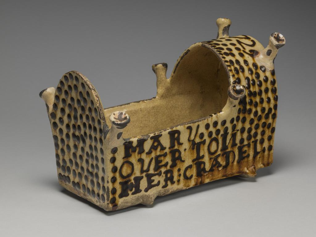 An image of Model Cradle/Commemorative Crib. Inscribed, 'MARY OVERTON – HER CRADEL, 1729'. Staffordshire pottery. Lead-glazed earthenware, slipware. English.
