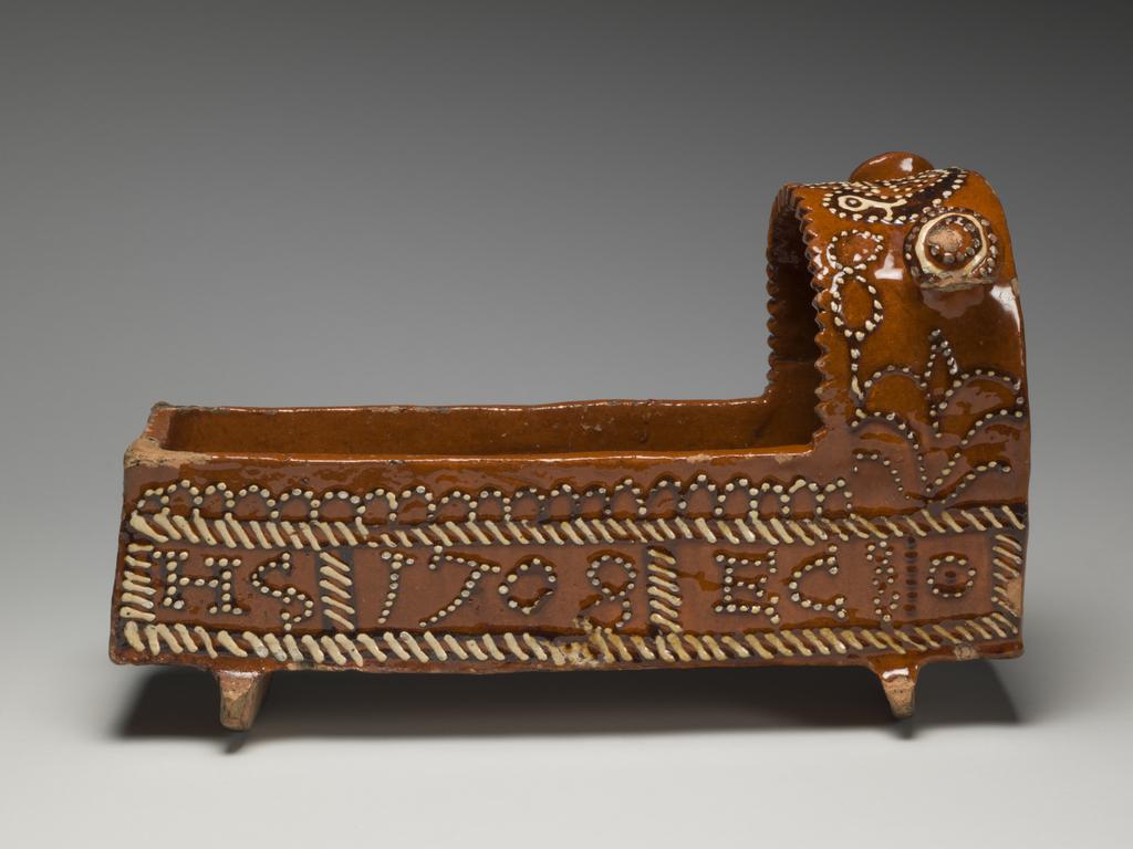 An image of Model Cradle/Commemorative Crib. Inscribed, 'JOHN WALKER, 1708'. Staffordshire pottery. Lead-glazed earthenware, slipware. English.