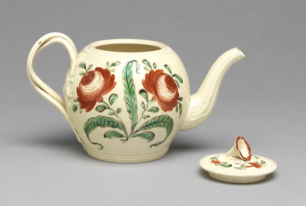 An image of Teapot and cover. Cockpit Hill Pottery, probably, England, Derbyshire. Painted in red, black and green enamels on one side with a parrot perched on a branch pecking at cherries, and on the other with roses. The ovoid pot has rouletted beading round the base and mouth, a curved fluted spout with pointed leaves round its junction with the body, and seven holes behind it to emit the tea. The double entwined reeded handle has four leafy termals. The almost flat cover has a rouletted beading border, a ventilation hole, and a convolvulus-shaped knob. One side is painted with a parrot perching in a tree and pecking cherries. The other side is painted with two large red roses and foliage. The cover is painted with three small floral sprays, and the flower knob has a red edging. Dark cream earthenware, thrown, and rouletted, with an applied moulded spout, reeded handles with moulded terminals, and applied knob on the cover. The lead-glaze is very slightly yellow. Height, whole, 11.5 cm, length, whole, 17.7 cm, circa 1765-1775. Rococo. Sir Ivor and Lady Batchelor Bequest through the Art Fund.