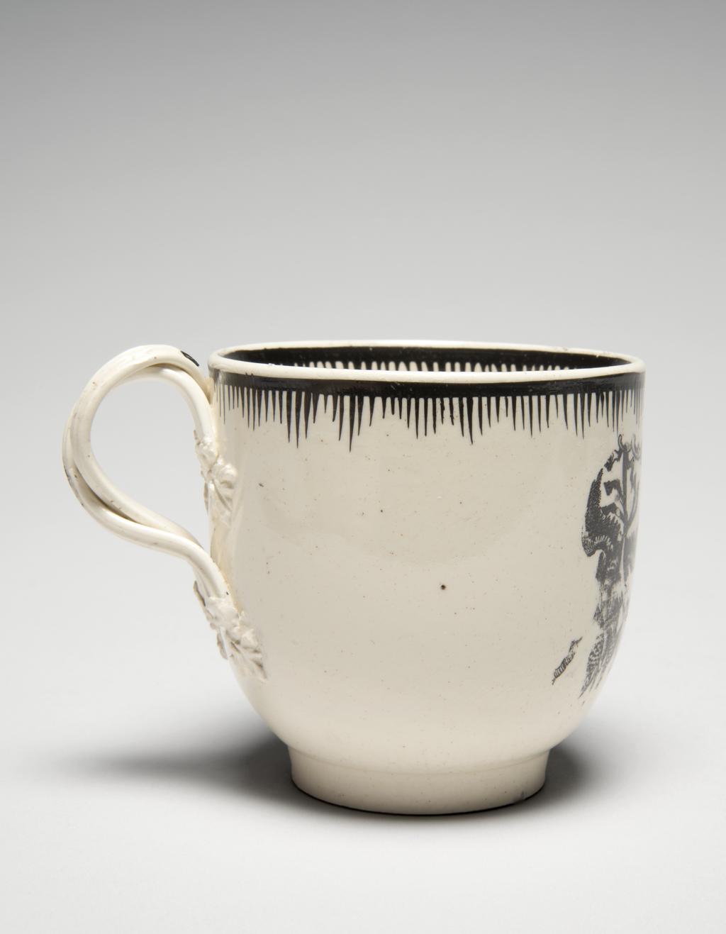 An image of Creamware chocolate cup and saucer, with Minerva and emblems of Wisdom and Industry. Neale & Co., factory, perhaps, Staffordshire. Leeds Pottery, factory, perhaps, Yorkshire. The cup stands on a low footring from which its sides curve outwards and then almost vertically upwards to the rim; reeded double intertwined loop handle with flower and leaf terminals. The saucer has a low footring and deep, concave curving sides. The front of the cup and the centre of the saucer are transfer-printed with a medallion with a medallion enclosing a figure of Minerva, various emblems of Wisdom and Industry and the motto 'LET WISDOM UNITE US', flanked by trophies of game. The interior of the cup is painted with an eight-petalled, stylised flower. Borders on both cup and saucer are composed of a horizontal band from which run close, vertical lines of varying lengths so as to form a rough zig-zag below the band. Cream-coloured earthenware, transfer-printed overglaze and painted in jet black. Pale yellow lead-glaze, inclining towards green where it lies thickly within the footrings. The base and exterior of the cup are lightly crazed with a fine mesh. Height, cup, 6.8 cm, diameter, saucer, 12.6 cm, circa 1780. Rococo.
