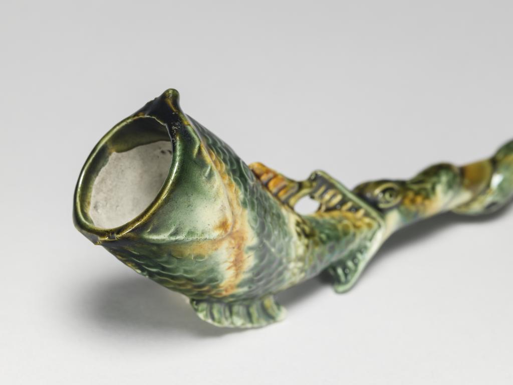 An image of Pipe in the form of a fish. Unknown pottery, Staffordshire. Cream-coloured earthenware, moulded, and decorated with green, yellow, and yellowish-brown lead-glazes and metallic oxides, circa 1755-1770. Rococo.