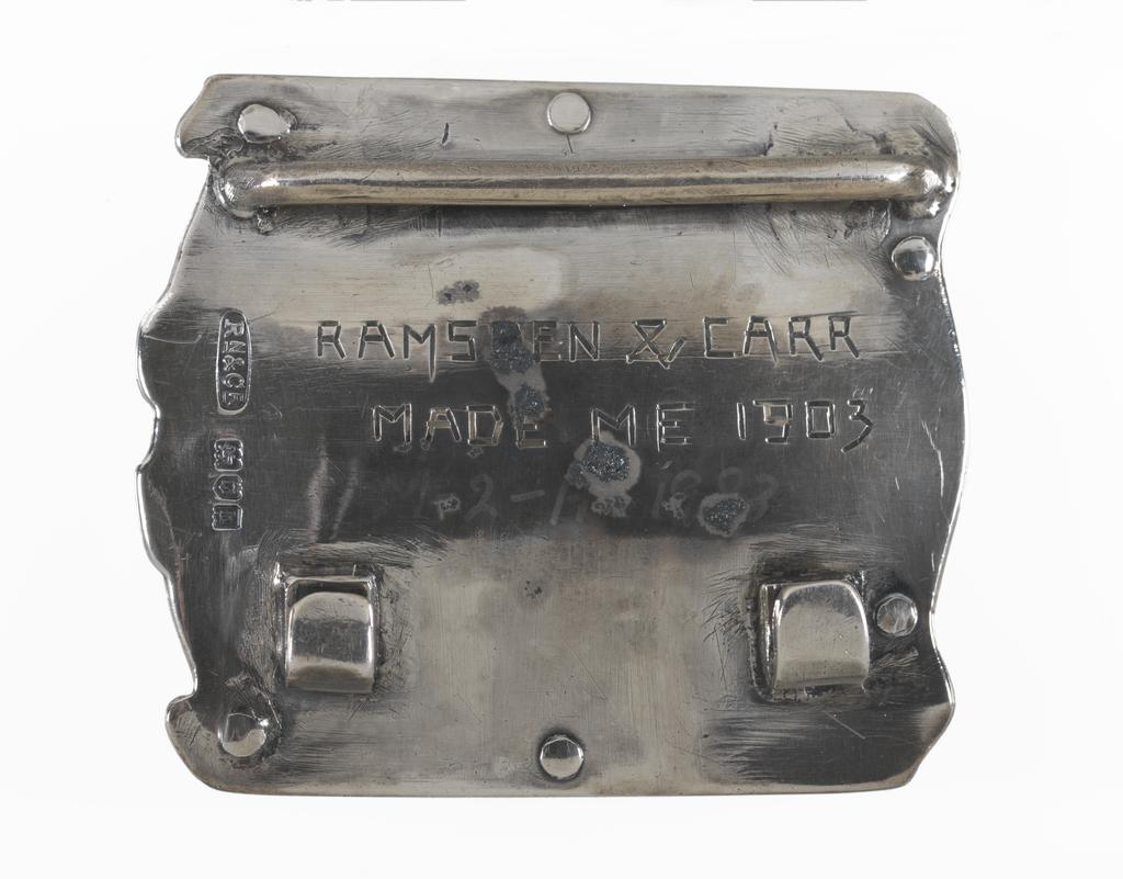 An image of Jewellery. Waist clasp. Ramsden and Carr. Ramsden, Omar (British, 1873-1939). Carr, Alwyn Charles Ellison (British, 1872-1940). Silver, chased and set with an oval plaque enamelled in blue, turquoise, green and white with a lyre bird. The silver back plate is inscribed 'RAMSDEN & CARR/MADE ME 1903'. Detached loop for the other end of the belt. Height, whole, 5.7 cm, width, whole, 5.0 cm, dated 1903. English. Acquisition: Grundy, J. Hull, Mrs.
