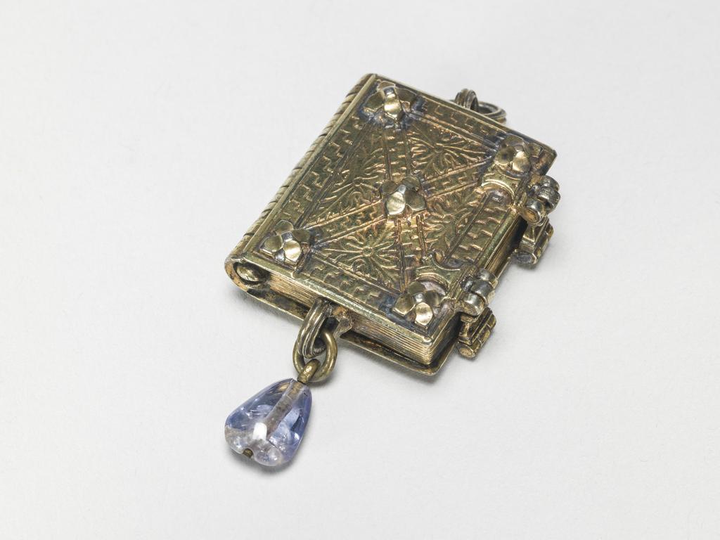 An image of Pendant Book. Jewellery/Pendant. Silver-gilt, with leaves made of silver and engraved with scenes from the Passion. Perhaps for attaching to a rosary, with pendant amethyst. Scenes: Annunciation, Nativity, Last Supper, Agony in the Garden, Kiss of Judas, Christ before Pilate, Scourying of Christ, The Mocking of Christ, Christ Carrying the Cross, the Erection of the Cross, Christ being Nailed to the Cross, the Crucifixion Deposition, Entombment, Resurrection, Christ Child Enthroned, a Pope and a female Saint. Silver-gilt, height, whole, 6.0 cm, width, whole, 2.8 cm, circa 1500- circa 1700. German.