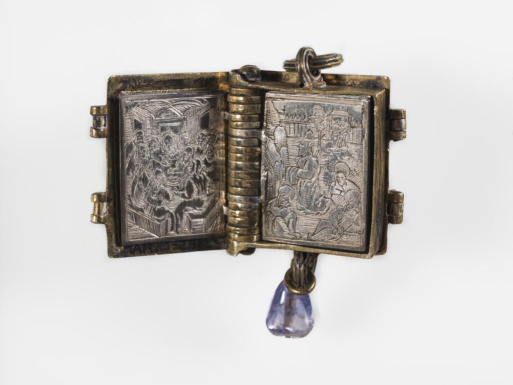An image of Pendant Book. Jewellery/Pendant. Silver-gilt, with leaves made of silver and engraved with scenes from the Passion. Perhaps for attaching to a rosary, with pendant amethyst. Scenes: Annunciation, Nativity, Last Supper, Agony in the Garden, Kiss of Judas, Christ before Pilate, Scourying of Christ, The Mocking of Christ, Christ Carrying the Cross, the Erection of the Cross, Christ being Nailed to the Cross, the Crucifixion Deposition, Entombment, Resurrection, Christ Child Enthroned, a Pope and a female Saint. Silver-gilt, height, whole, 6.0 cm, width, whole, 2.8 cm, circa 1500- circa 1700. German.