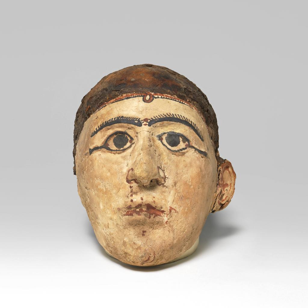 An image of Mummy trappings. Mummy mask, moulded on male skull. Production Place/Find Spot: Egypt. Depth 0.12 m, height 0.23 m, length 0.1475 m.
