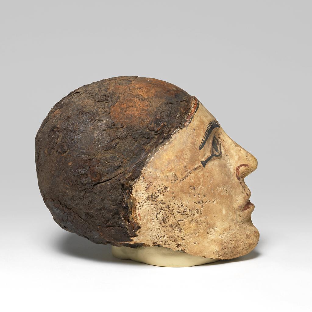 An image of Mummy trappings. Mummy mask, moulded on male skull. Production Place/Find Spot: Egypt. Depth 0.12 m, height 0.23 m, length 0.1475 m.