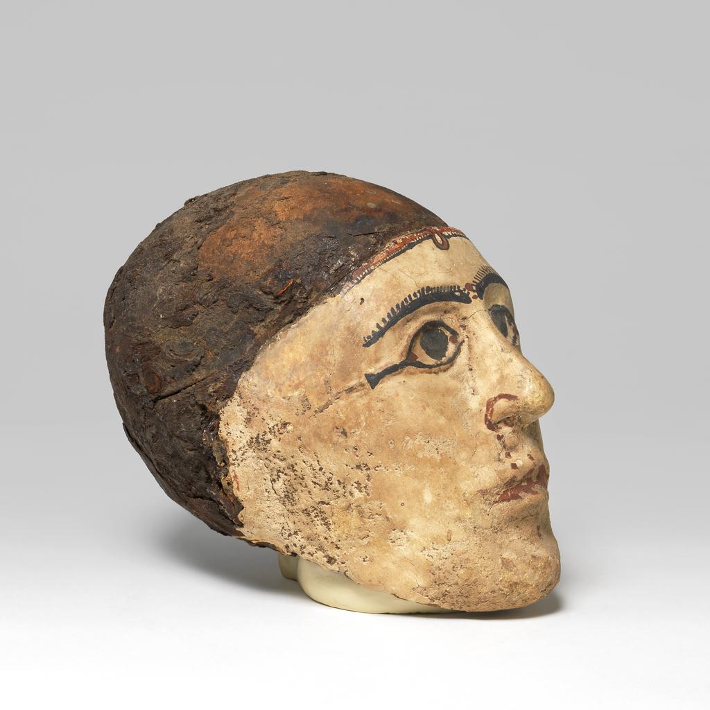 An image of Mummy trappings. Mummy mask, moulded on male skull. Production Place/Find Spot: Egypt. Depth 0.12 m, height 0.23 m, length 0.1475 m.