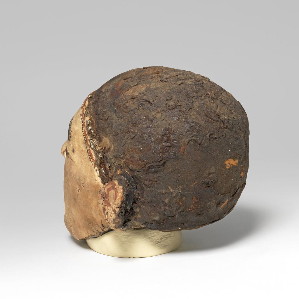 An image of Mummy trappings. Mummy mask, moulded on male skull. Production Place/Find Spot: Egypt. Depth 0.12 m, height 0.23 m, length 0.1475 m.