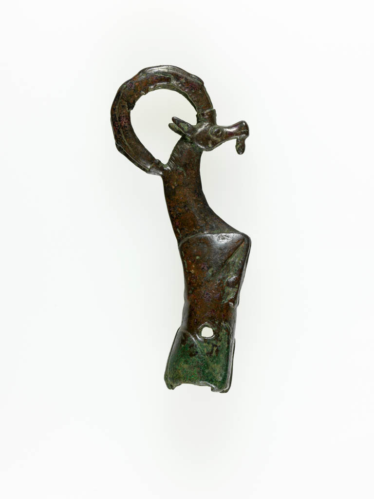 An image of Equipment. Handle of whetstone, in form of crouching ibex. Find Spot: Luristan ? Iran/Iraq. Copper alloy, circa 900-701 BC.