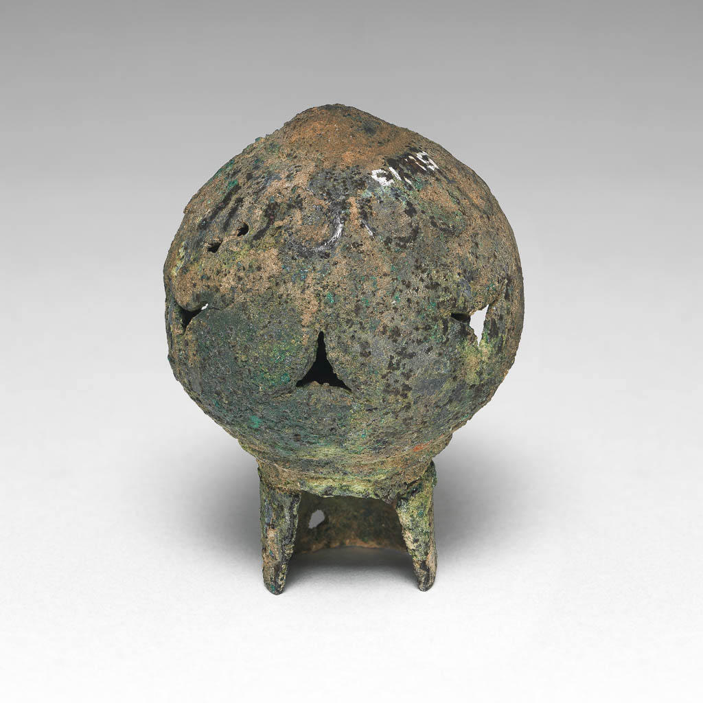 An image of Equipment. Finial. Spear butt or terminal, spherical with cut-out decoration. Production Place: Syria. Find Spot: Deve Hüyük, Syria. Copper alloy, height 6.3 cm, diameter 1.89 cm, diameter 4.57 cm.