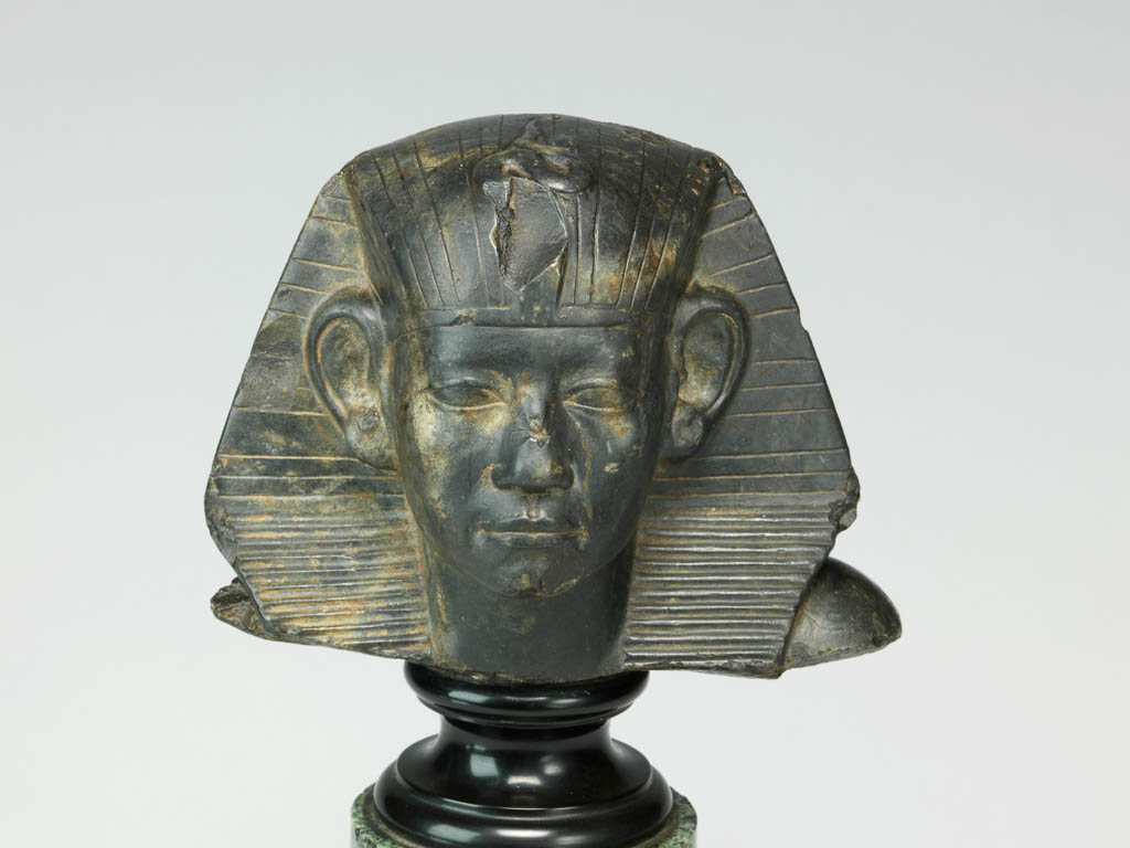 An image of Statue/Figure. Head of King Amenemhet III, wearing nemes head-dress. Find Spot: Aswan, Egypt. Shelly limestone, length 12 cm, width 14.3 cm, circa 1831-circa 1786 B.C. Twelfth Dynasty, Middle Kingdom. Reign of Amenemhat III. Production Notes: Only the shoulders and head are preserved; the base is modern. The statue was found in a private tomb. The facial features are a softer version of the so-called 'realistic portraits' of Senusret III. In this way the ruler was able to promote a visual link to his predecessor.