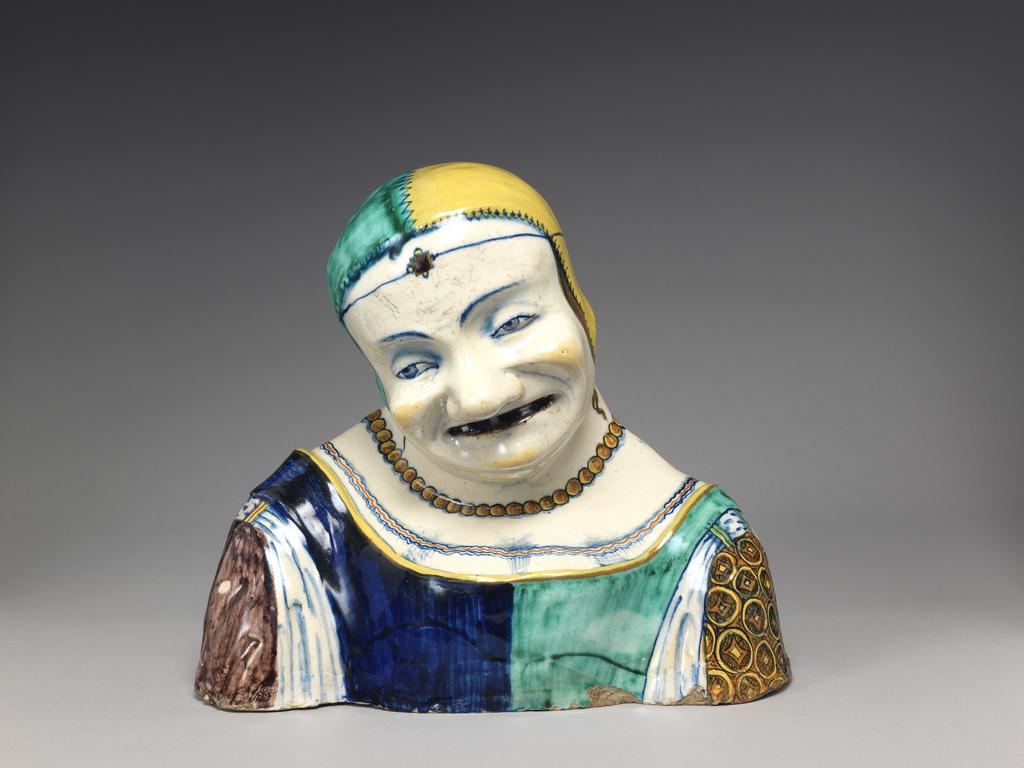 An image of Maiolica. Bust of an old woman. Production Place: Italy, Emilia-Romagna, Faenza (probably). Pale buff earthenware, tin-glazed on the exterior; underside unglazed. Painted in dark blue, green, yellow, orange, manganese-purple, and black. height, whole, 20.9 cm, width, whole, 24.0 cm, circa 1490-1510. Renaissance.