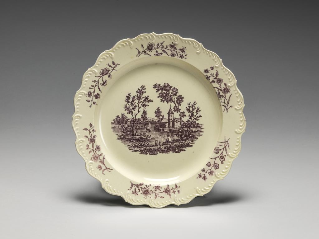 An image of Plate. Wedgwood, Josiah (English potter 1730-1795). Made in Josiah Wedgwood's factory at Burslem and printed in Liverpool by Sadler and Green. Circular with wavy edge, narrow sloping rim, shallow curved sides, and flat centre. Decorated in the centre with a vignette showing a man fishing beside a lake, flanked by buildings and trees, and on the rim with six floral sprays. Cream-coloured earthenware (Queen's ware), moulded with featheredge, and printed onglaze in lilac, diameter, whole, 19.4 cm, circa 1765-1770. Rococo.