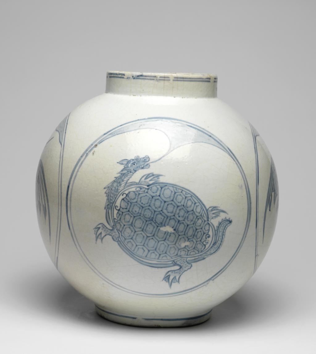 An image of Large jar with tortoise and crane designs. Unknown pottery, Korea, Kwangju, Punwon-ri kilns. The body of this jar is almost globular and the neck straight; the foot is wider than the neck, giving the jar a stable appearance. In four roundels around the sides, divine tortoises and cranes are arranged in alternation, with a cloud or auspicious vapour issuing from the mouth of each tortoise, and with lots of free space around the designs. The glaze is of milky-white colour and crackled, the body is thick and heavy. On the base is an unexplained straight incised line and traces of sandy supports adhere to the footring. Porcelain, thrown, painted in cobalt-blue, and glazed, height, whole, 31.0 cm, diameter, rim, 14.0 cm, diameter, foot, 15.0 cm, circa 1750-1800. Choson Dynasty (1392-1910). Notes: Such jars (hangari) were used as wine vessels.