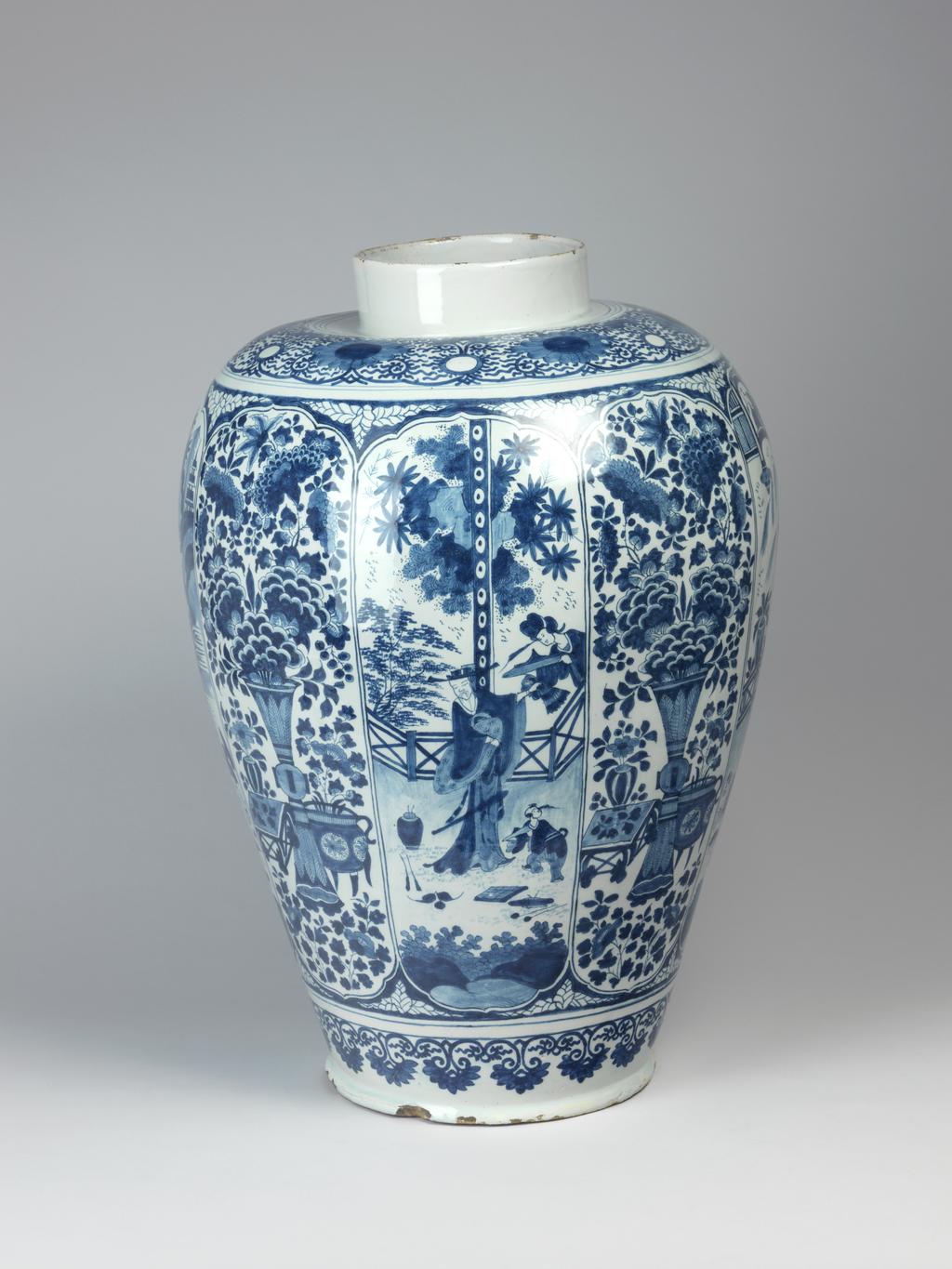 An image of Delftware. Vase. Drie Posteleyne Astonne, Holland, Delft. The sides are decorated with eight vertical panels painted alternately with Chinese figures in gardens and landscapes or a large vase of flowers and foliage flanked by a vase of flowers on a table and flowers in a three-legged cauldron. Below there is a horizontal band of scrolls with pendant leaves, and round the shoulder a border of formal flower heads and scrolls. Pale buff earthenware, thrown, tin-glazed, and painted in blue, height, whole, 55 cm, diameter, base, 22 cm, circa 1685-1700. Chinese Style. Production Note: On accession by Glaisher the vase was attributed to Ghisbrecht Lambrechtz Kruyk or Cruyck, but without evidence. The GK mark is now attributed to Gerrit Pietersz Kamm the proprietor of the Drie Posteleyne Astonne between 1679 and 1700.