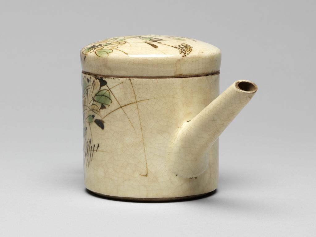 An image of Japanese pottery. Spouted pot with handle and lid. Unknown, pottery, Kyoto, Awata. Pot with long spout and lid. 'Square' handle and a long spout. Decorated on knobless lid and one side with flowers in green, yellow and brown brushwork. Stoneware, thrown and turned with ivory-coloured glaze, brush painted with green, yellow and brown, height, whole, 9.20 cm, diameter, 8.10 - 16.40 cm, circa 1800-circa 1899. Edo period (1615-1868) / Meiji period (1868-1912).