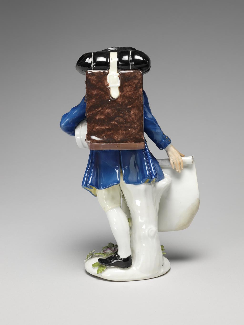 An image of A map-seller. Meissen Porcelain Manufactory, Saxony. With his right hand he holds out a map of the British Isles, in the lower proper right corner figures of Mercury and Britiannia with a bale of merchandize. Under his left arm he carries a white band box. On his back, slung from his shoulders by yellow straps, he carries a mottled-brown cabinet with nine drawers, on top of which is a black hold-all secured by a broad cream-coloured strap. Hard-paste porcelain, press-moulded, glazed, and painted in enamels and gilt, height, whole, 16.9 cm, width, 10 cm, circa 1750-1755. After a model of 1744. Production Note: This model was based on the first print of the third set of Etudes prises dans le bas peuple ou les Cris de Paris, issued in 1738, engraved by the comte de Caylus (1692-1765) after drawings by Edmé Bouchardon (1689-1762) . It is smaller than the first figure modelled after this engraving in 1744. Unusually, the map seller holds a map of the British Isles.