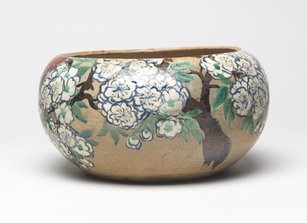 An image of Japanese pottery. Bowl, with lid missing. Kenzan pottery studio. Production Place: Japan, Kyoto. Jar (without the lid) of globular shape. Inset base. Buff base glaze with decoration of spring flowers, namely cherry blossom and camellias in white, red, blue, yellow, also leaves in green and black, trunk and branches in brown and black. Stoneware, thrown and turned, brush painted, height, whole, 11.70 cm, diameter, rim, 16.20 cm, diameter, bowl, 22.50 cm, diameter, base, 13.00 cm, circa 1800-circa 1899. Edo period (1615-1868) / Meiji period (1868-1912).