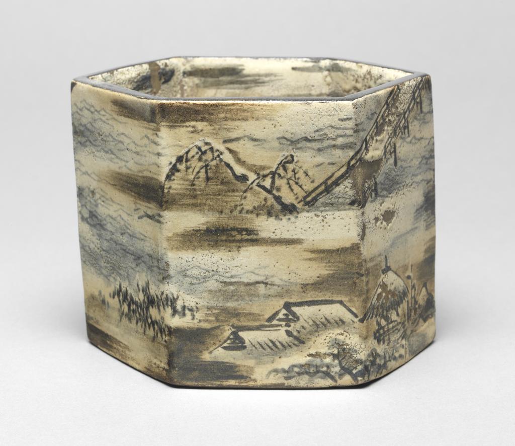 An image of Japanese pottery. Ember pot. Ogata, Kenzan (1663-1743). Ogata, Korin (1658 -1716). Production Place: Japan, Kyoto. Hexagonal brown stoneware pot, slab-built with lifted base. Winter landscape decoration continues round all six sides, comprising temple by a lake, house, gazebo, trees, clouds and waves, in subdued colours; cream, blue, brown, black. Black rim. Cloud decoration continues inside. Stoneware, hand-built, with brush painting pigments, height 10.90 cm, diameter, rim, 14.20 cm, diameter, base, 14.50 cm, 1658-1743. Edo Period (1615-1868). Production Note: the landscape is almost certainly by Korin.