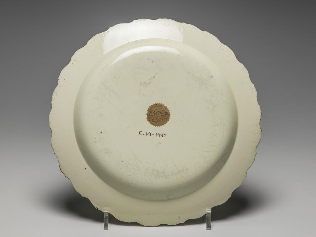 An image of Plate. Corinthian Ruins. Wedgwood, Josiah (English potter, 1730-1795). Green, Guy, printer (British ceramist, act.1756-1799). This design was known as Corinthian Ruins, but was derived from plate 1 in Robert Sayer's, The Ruins of Athens. Circular with featheredge, sloping rim, shallow curved sides, and flat centre. Decorated in the middle with Bridge over the River Ilissus and the Temple of Pola in Istria, and on the rim, with six floral sprays. Cream-coloured earthenware (Queen's ware), moulded, lead-glazed, and printed onglaze in black, height, whole, 2.3 cm, width, whole, 24.3 cm, circa 1770-1775. Rococo.