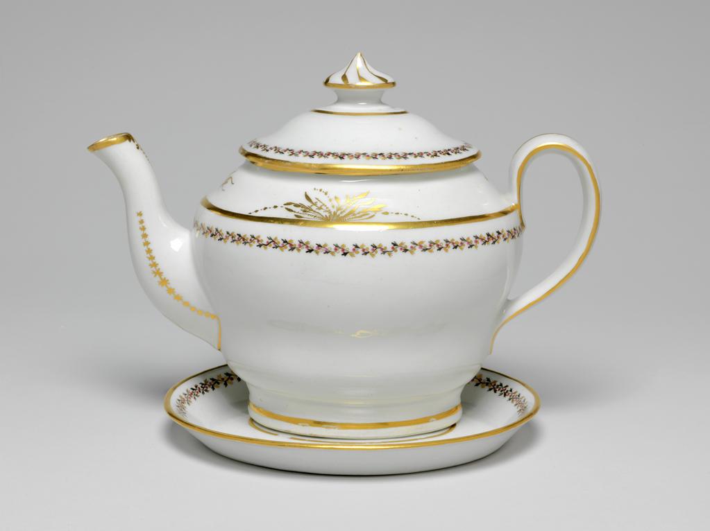 An image of Teapot and stand. New Hall Porcelain Factory, Staffordshire. The teapot and cover (A) are of oval ogee form. The stand (B) is oval with sloping sides and flat base. There are ten holes forming an ellipse surrounding one hole behind the spout, one ventilation hole in the cover, and anothe under the knob. The exterior of the pot is decorated below the shoulder by border comprising a wavy black stem with tiny trefoil leaves, puce berries, and gold trefoil leaves. Above the shoulder there is an an arrangment of gold foliage on each side of the pot and a gold sprig at each end. Gold bands run found the footring, the shoulder, the rim, the sides of the handle, and the tip of the spout. There is a vertical gold line down the back of the handle. Each side of the spout is decorated with a row of gold stars over a line which runs on round its junction with the body. Below the lip there is a gold wavy dotted line over a vertical row of narrow leaves altenating with spots. The cover is decorated en suite, and has eight swirling gold lines radiating from the top of the knob. The stand has a central stylized star-like flower surrounded by an oval gold band, a matching border, and a gold band on the edge. Pattern no. 280. Hybrid hard-paste porcelain, moulded, glazed, painted overglaze with black and puce enamel, and gilded. Height, teapot, 17.5 cm, length, teapot, 24.2 cm, height, stand, 2 cm, length, stand, 17.7 cm, width, stand, 14.6 cm, circa 1797-1803.