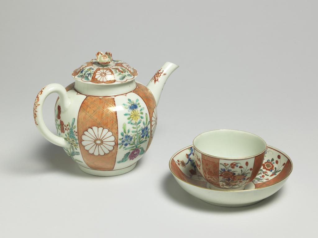 An image of Teapot and cover. Worcester Porcelain Factory. Giles, James, probably (British porcelain painter, 1718-1780, London). The globular teapot has a curved spout and ribbed loop handle, and a low footring. The slightly domed cover has a flower knob. The sides of the teapot are painted, probably in the atelier of James Giles, with a Japanese pattern, with four upright orange-ground panels with gilt trelliswork, each with a chrysanthemum head mons in reserve, separated by four flower sprays in famille-rose style. The handle and spout have a rococo motif in red. The cover is painted in en suite. Soft-paste porcelain, lead glazed, painted in orange, red, yellow, green, blue and pink enamels, and gilt, height, whole, 14.0 cm, length, whole, 19.3 cm, circa 1765-1768. Japanese Style.