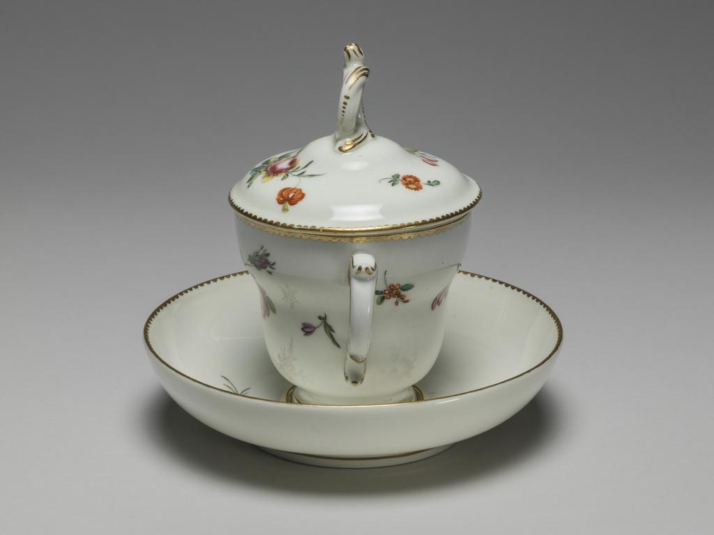 An image of Chocolate cup with cover and saucer. Chelsea-Derby Porcelain Factory. Soft-paste porcelain, decorated with flowers in polychrome onglaze enamels, height, cup and cover, 5 1/4 in, width, cup and cover, 5 in, height, saucer, 1 1/2 in, diameter, saucer, 5 3/4, in, circa 1775. Chelsea-Derby Period.