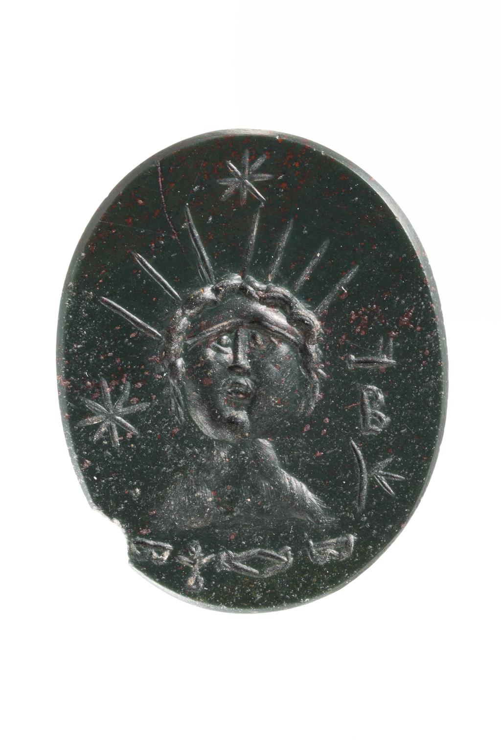 An image of Engraved gems. Magical amulet. Obverse: a bust of Helios, full-face, with a crown of seven rays set upon curly, loosely cropped hair. Above and to the left of the head hang two stars. The neck and shoulders are very roughly worked and are possibly meant to represent a rocky mountain. in the field are various letters and signs. Reverse: crescent and three stars. Intaglio cutting, bloodstone, 23 mm x 18 mm, circa 200-circa 400 AD. Roman Imperial.