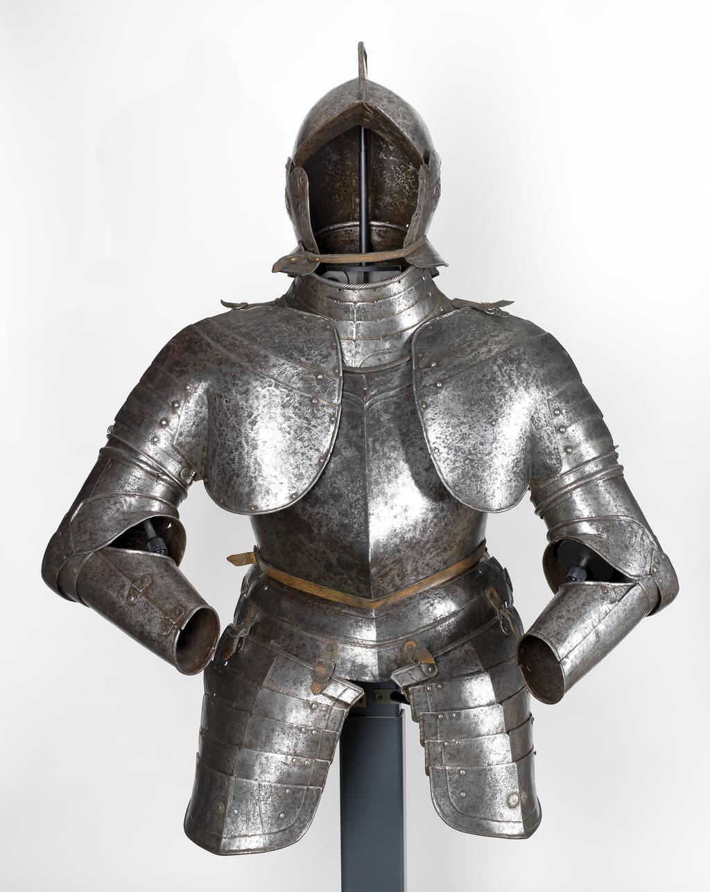 An image of Armour/half armour. Unknown production, Germany. Half armour consisting of a burgonet, an 'Almain' collar, a cuirass, a pair of short tassets, and two pauldrons and vambraces, nearly forming a pair. Most of the armour originally had a 'black from the hammer' finish, now cleaned to a mottled bright finish with medium to heavy pitting overall. Steel, hammered, riveted. Circa 1550-1610. Notes: all within these dates apart from the pair of short tassets, which have been partly reworked and formed of 16th century plates in the 19th century. Provenance: From the armoury of the Princes Radziwill, Castle of Niescwiez, Poland. Parts: HEN.M.1C-1933HEN.M.1B-1933HEN.M.1A-1933HEN.M.1D-1933HEN.M.1E-1933
