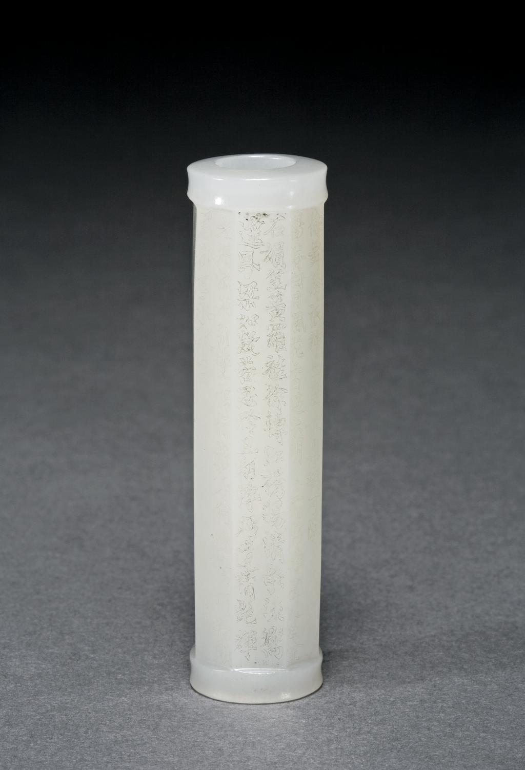 An image of Bead, tubular shape. White jade, eight sided tubular bead with very fine inscriptions on each side of the Cong, tube. Nephrite, height 6.2 cm, diameter 1.6 cm, 1850-1900. Chinese.