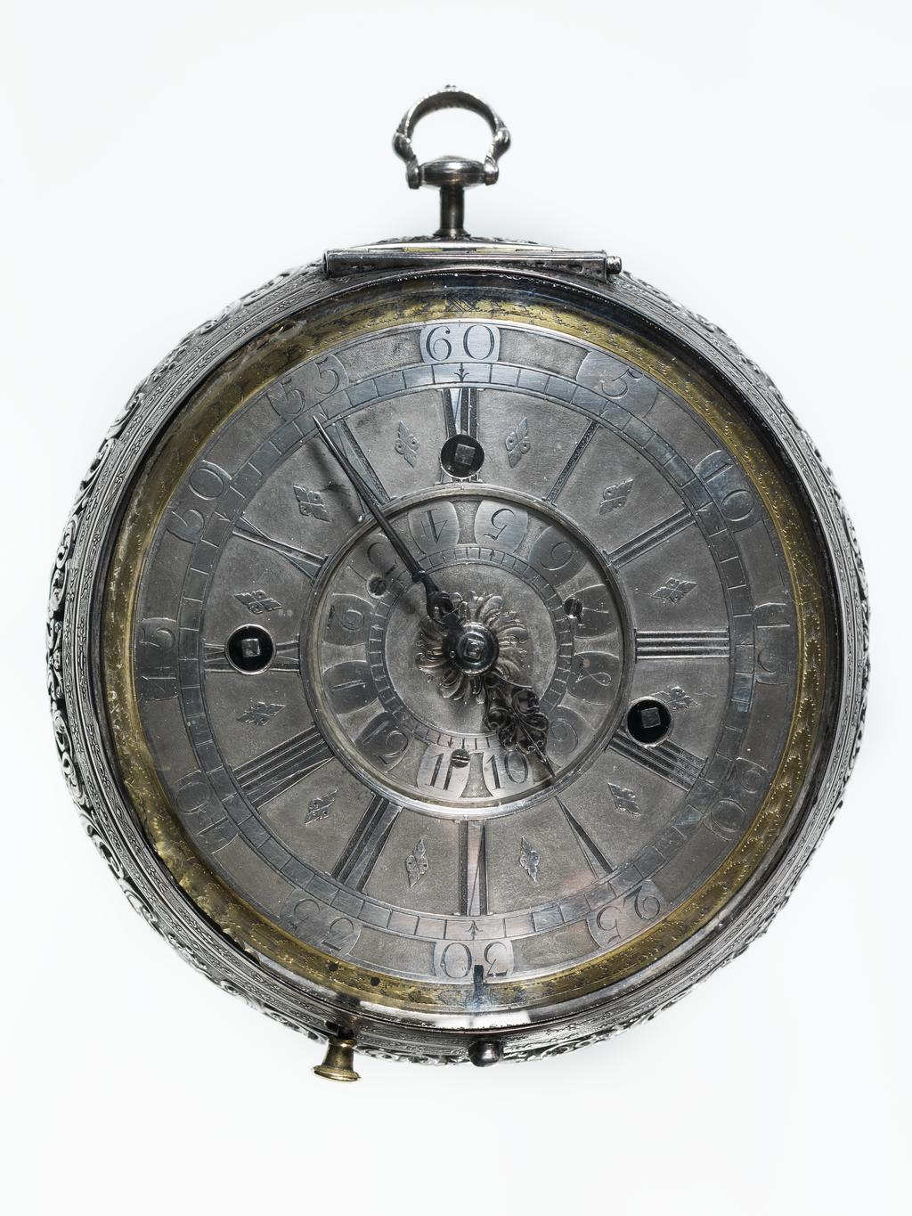 An image of Verge alarm coach watch. Movement: Thomas Windmills, London, c. 1725; case probably by Sarah Jaques and John Lee, London. Movement: brass, silver and steel, engraved ‘Thomas Windmills LONDON 7303’. Dial: silver champlevé with blued steel hour and minute hands. Case: silver, pierced and chased with four repoussé panels from Aesop’s Fables. Interior stamped with maker’s mark incuse ‘SI IL’. Case: height 13.9 cm, diameter 12.6 cm, depth 6.1 cm, circa 1725. London. 